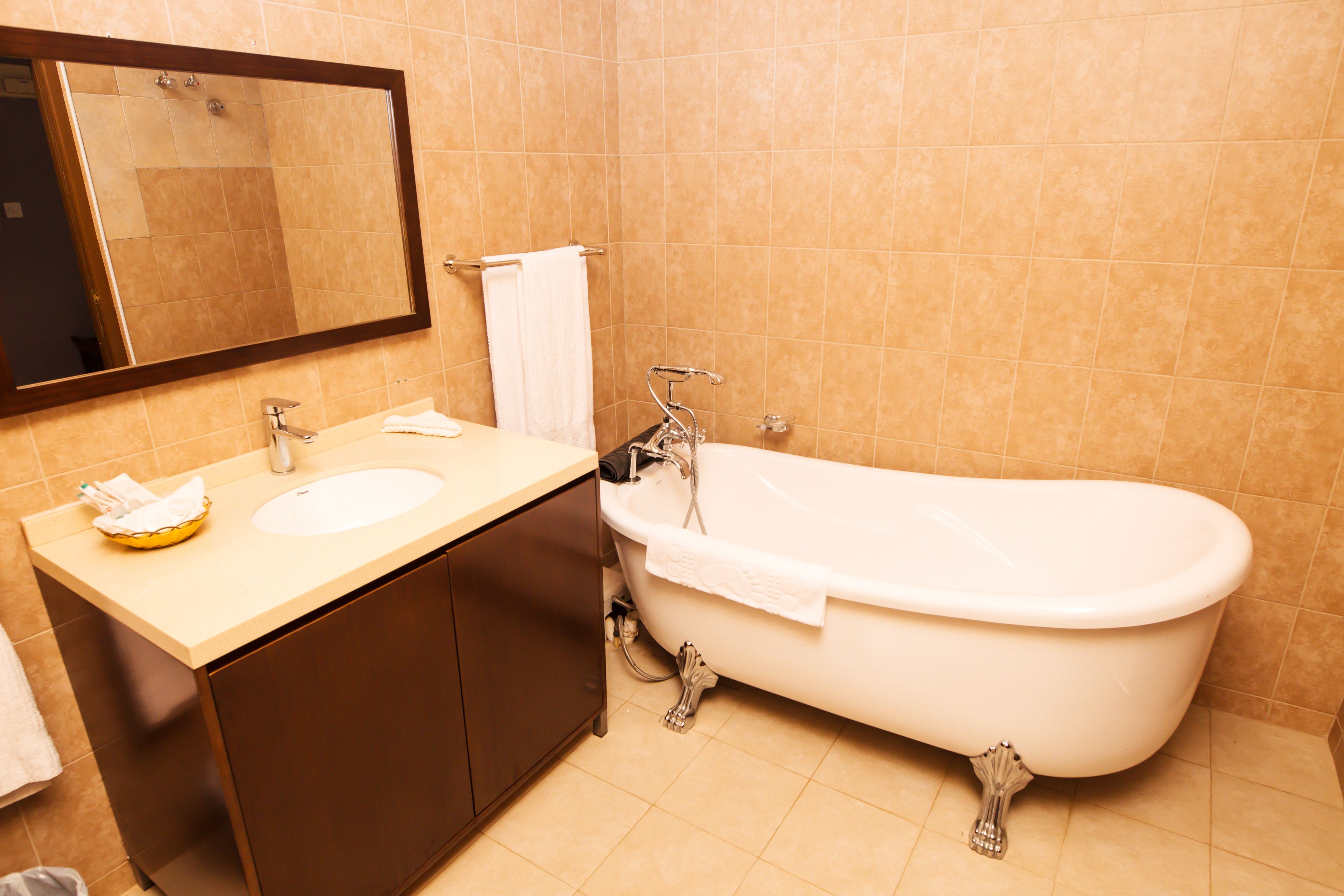 Un baño con bañera, lavabo y espejo.