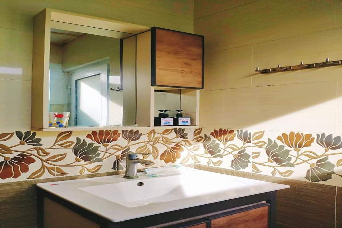 Une salle de bain avec un lavabo blanc, un miroir au-dessus et un meuble en bois en dessous.