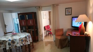 A living room with a dining table, chairs, a TV, and a lamp. - SEGESTA - Le Bouquet (Salemi)