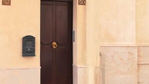 A building with a dark brown door, numbered 52 and 50, and a small mailbox on the wall. - SEGESTA - Le Bouquet (Salemi)