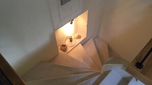 Una escala amb un petit nínexe superior, que conté una espelma i un objecte decoratiu petit.