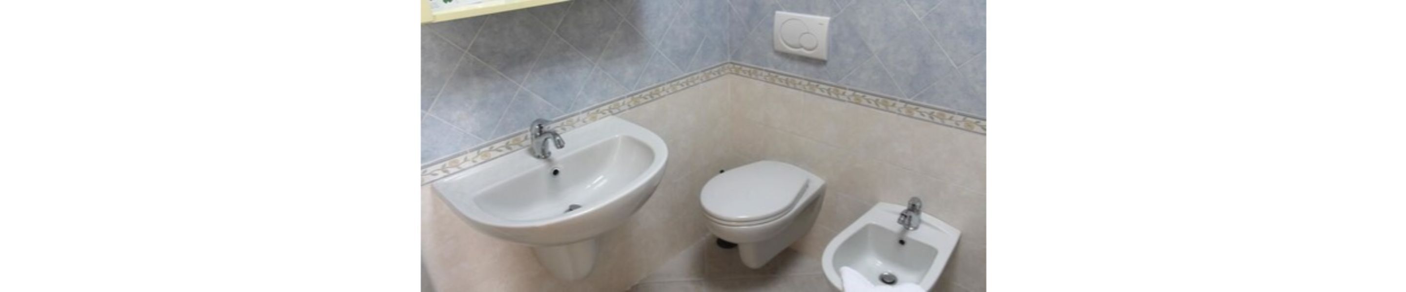 Une salle de bain équipée de toilettes, d’un bidet et d’un lavabo.