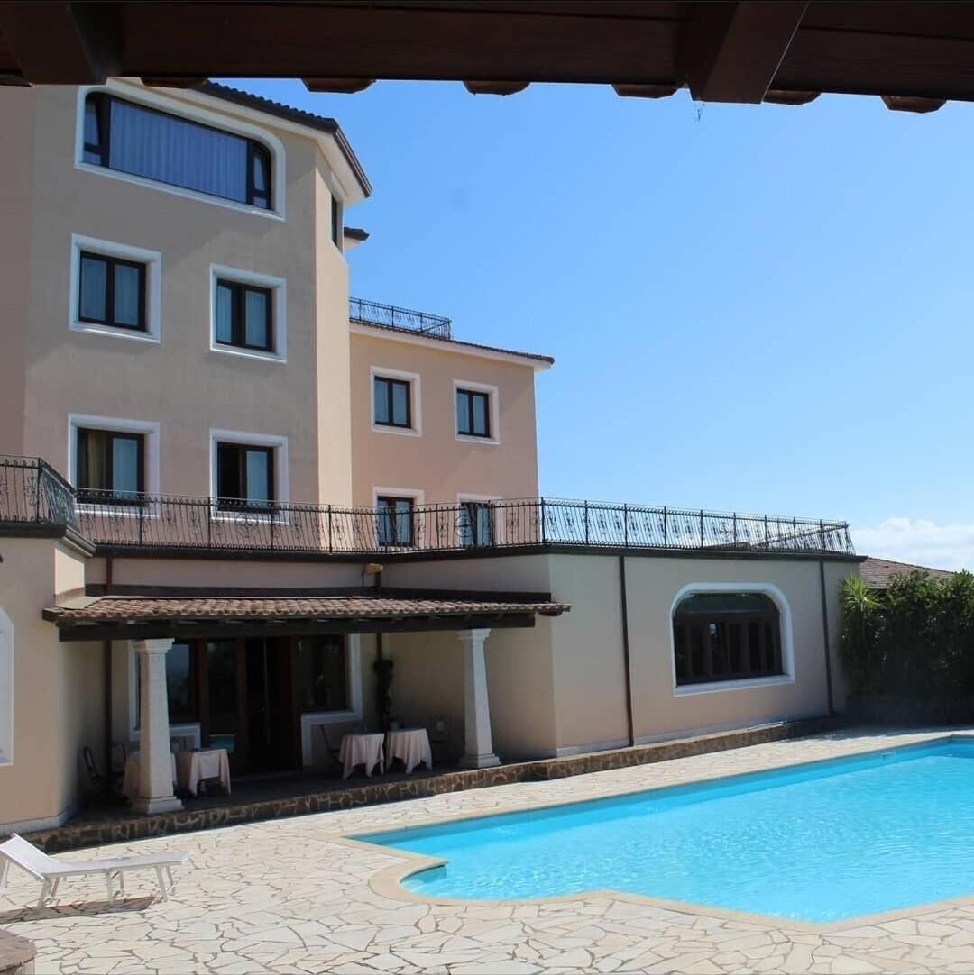 Een seizoensgebonden buitenzwembad, ligstoelen bij het zwembad