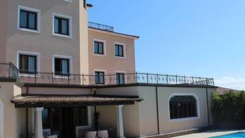 Een seizoensgebonden buitenzwembad, ligstoelen bij het zwembad