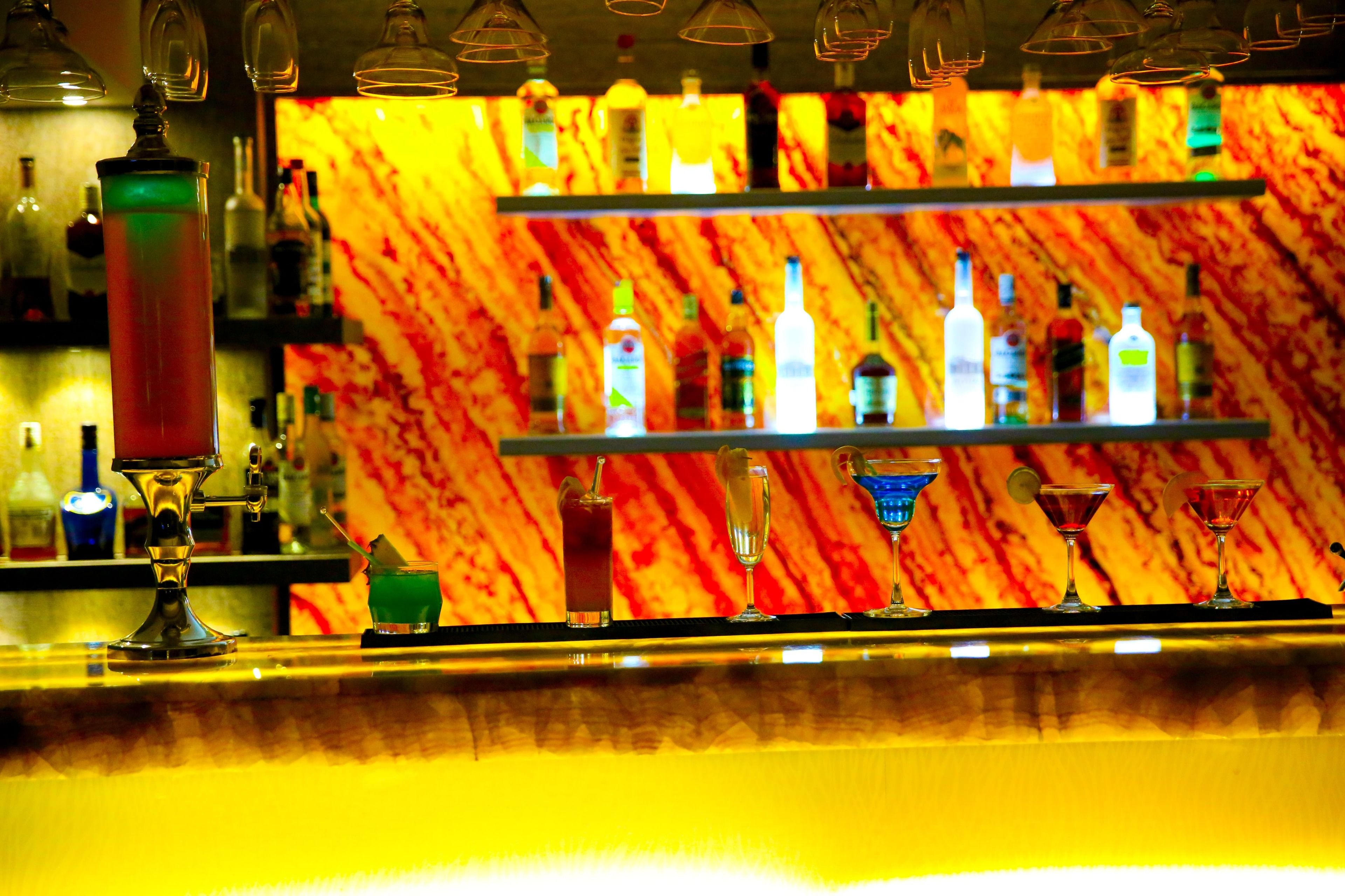 A bar area with shelves of bottles and glasses.