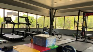 A gym with various exercise equipment, including a treadmill, elliptical, and weightlifting area. - HOTEL ROCK FORT VIEW by Park Elanza (Tiruchirappalli)