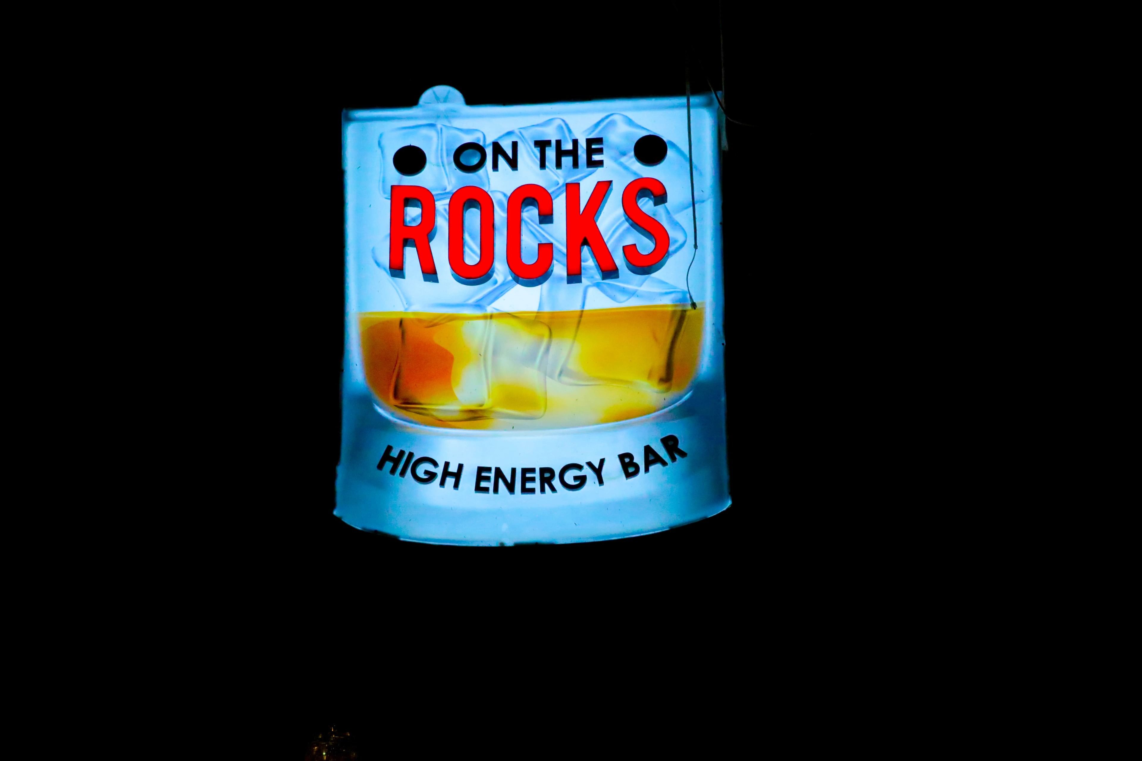 Neonvalomainos, jossa lukee: ”ON THE ROCKS HIGH ENERGY BAR”.