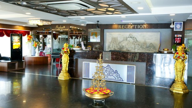 A reception area with a reception desk, a statue, and a decorative altar. - HOTEL ROCK FORT VIEW by Park Elanza (Tiruchirappalli)
