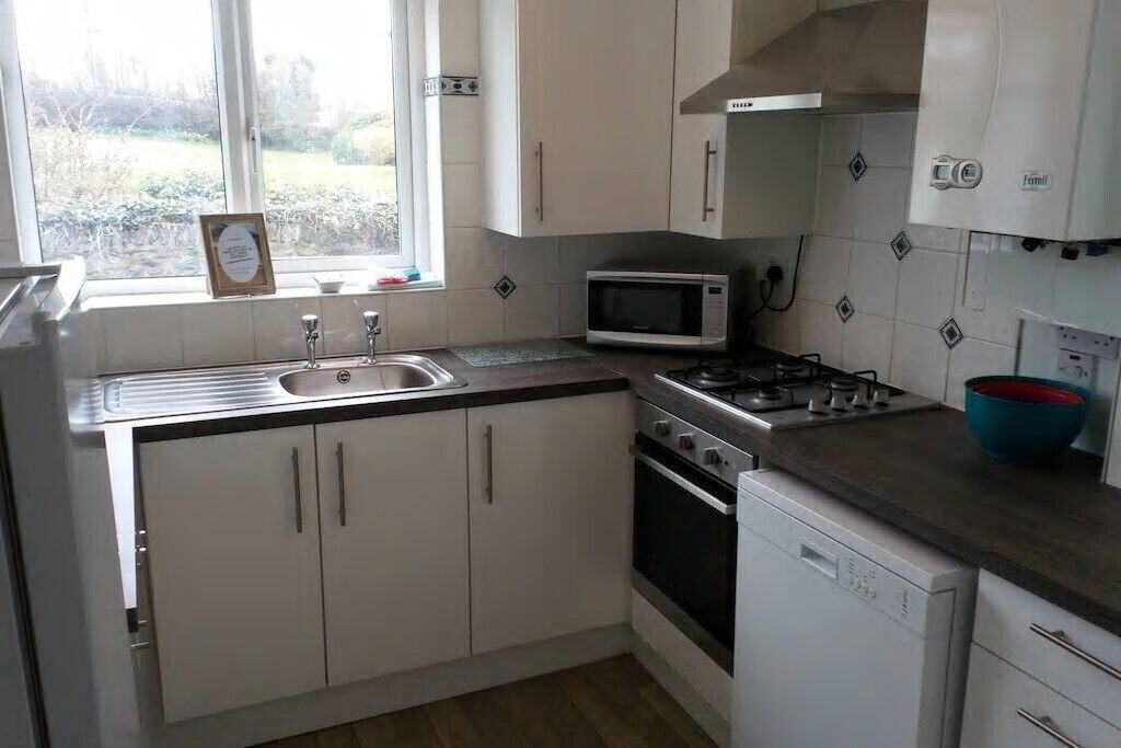 A kitchen with white cabinets, a microwave, a stove, and a dishwasher.