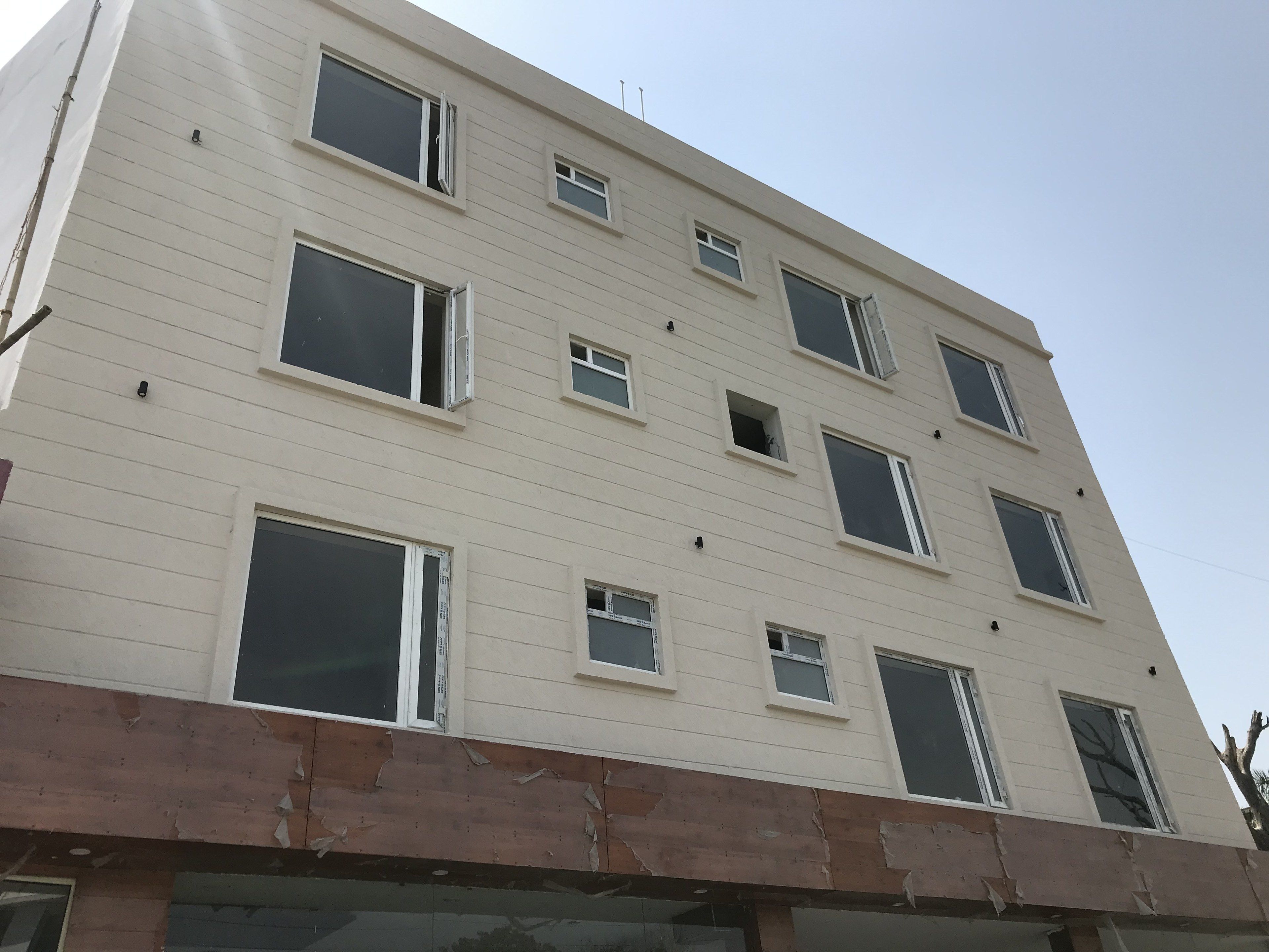 A multi-story building with several windows, some of which are open.