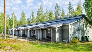 A row of single-story cabins with attached porches, surrounded by a grassy area and trees.