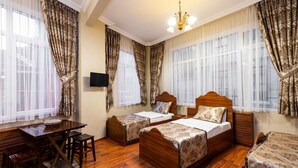 A hotel room with two wooden beds, a wooden desk, a television, and large windows with curtains. - The First Ottoman Suites (Istanbul)