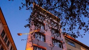 A multi-story building with large windows and a brick facade, located in an urban setting with cobblestone streets. - The First Ottoman Suites (Istanbul)