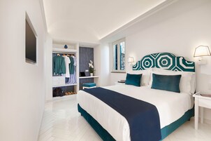 Ein Schlafzimmer mit einem großen Bett, einem Kleiderschrank, einem Frisiertisch und einem Fenster.