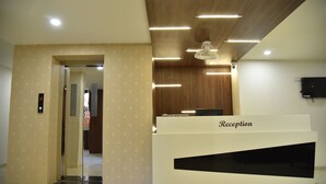 Zona de recepción con diseño moderno, que incluye un mostrador de recepción con la etiqueta 
