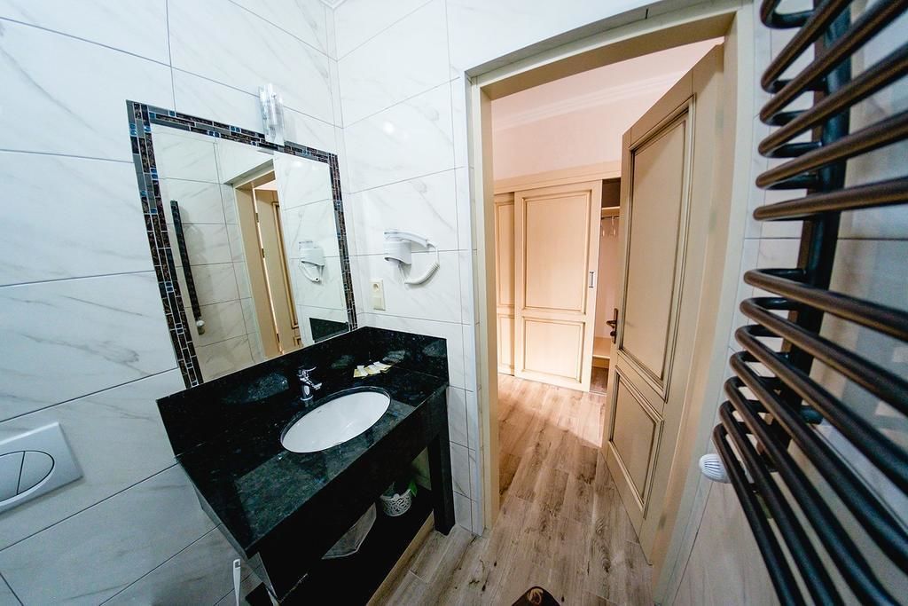 A bathroom with a black sink, a mirror, and a towel rack.
