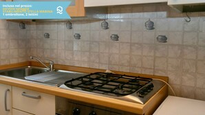 A kitchen with a gas stove, sink, and tiled backsplash. - N099 - Numana, delightful apartment 150mt from the sea (Numana)