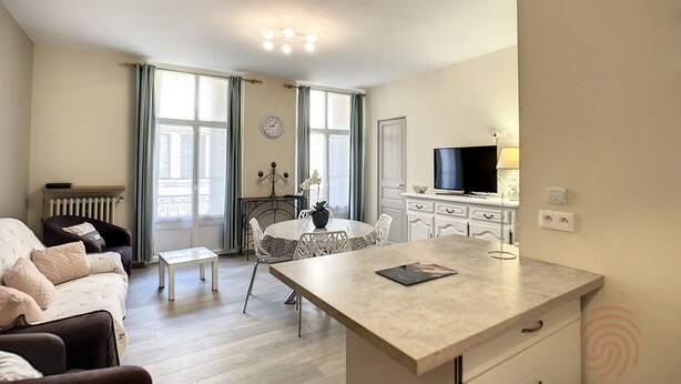 Ein modernes Wohnzimmer mit einer Couch, einem Esstisch und einem Fernseher.