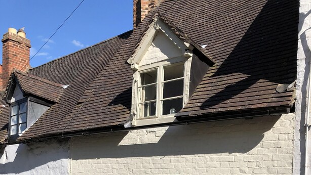A white brick building with a red door, a window, and a small balcony. - Award Winning Little Gem on the Historic Cartway (Bridgnorth)