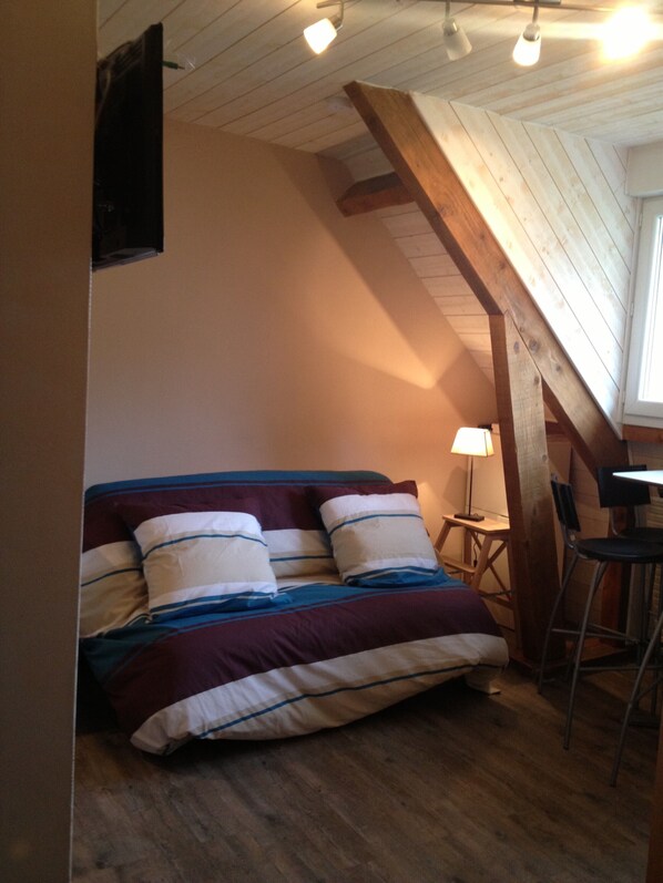 A bedroom with a bed, a nightstand, a chair, and a lamp. - Studio in the mountains / Lans en Vercors (Lans-en-Vercors)