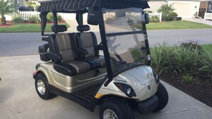 A golf cart with a covered seating area and a steering wheel. - Village of Fernandina - free use of golf cart with liability waiver (The Villages)