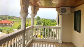Un balcone con ringhiera bianca, soffitto esagonale e condizionatore d'aria.