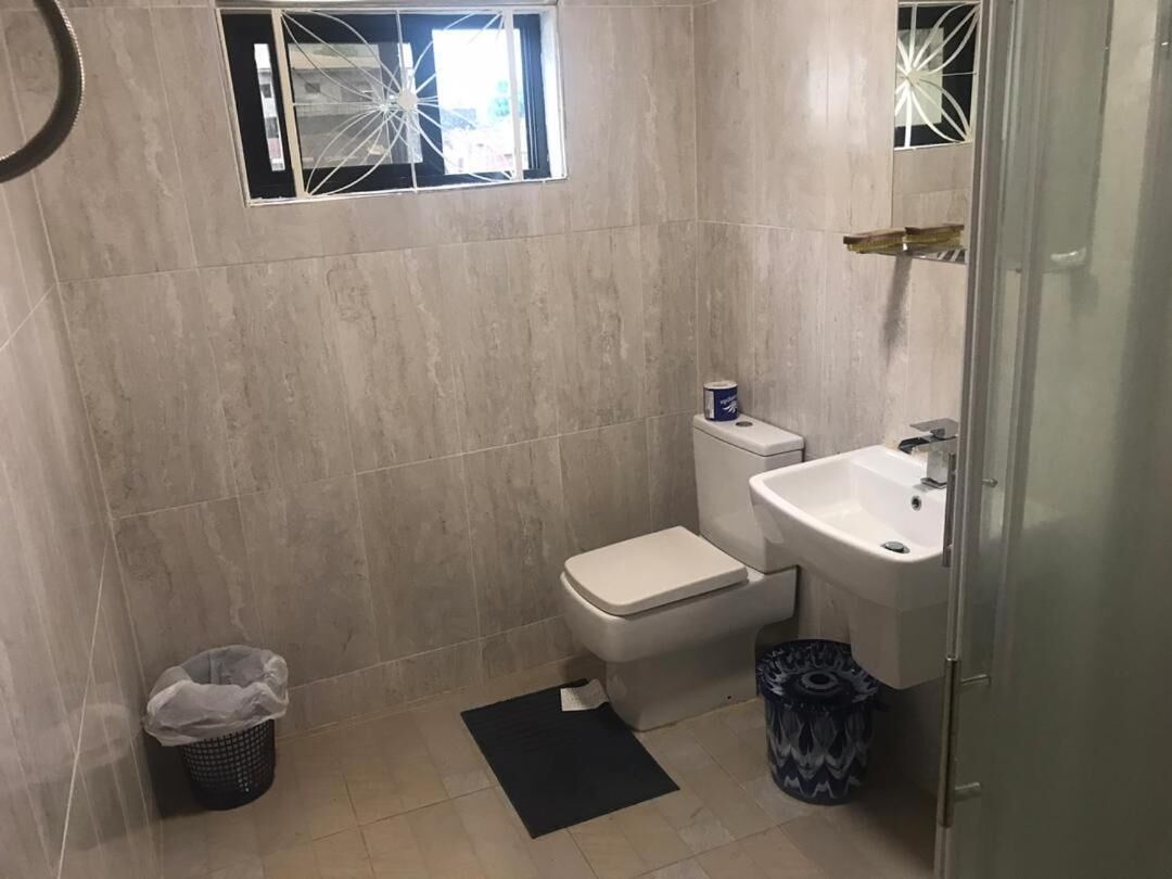 Uma casa de banho pequena com sanita, lavatório e uma janela.