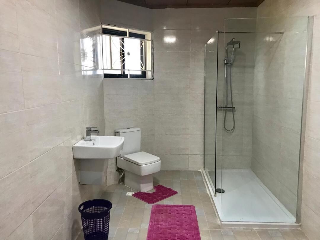 A bathroom with a glass-enclosed shower, a sink, and a toilet.