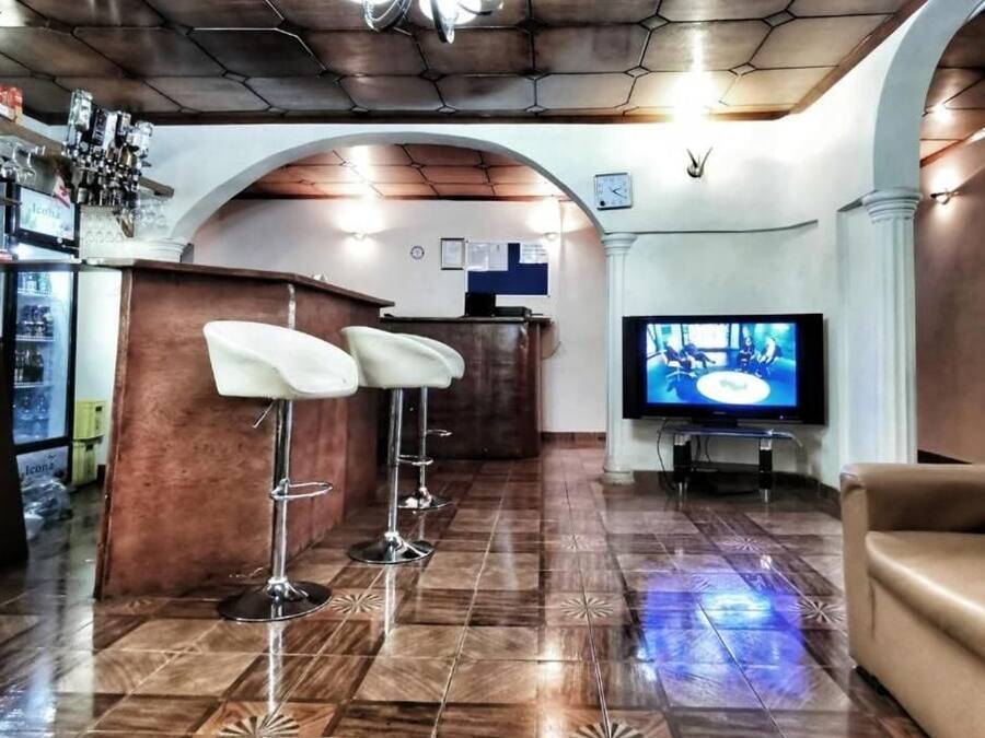 A bar area with stools, a television, and a bar counter.