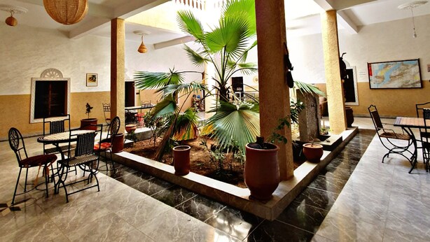 A spacious indoor area with a central garden, seating arrangements, and a ceiling with decorative elements. - Chambres d'Hôtes Riad Dar Tazoulte (Agdz)