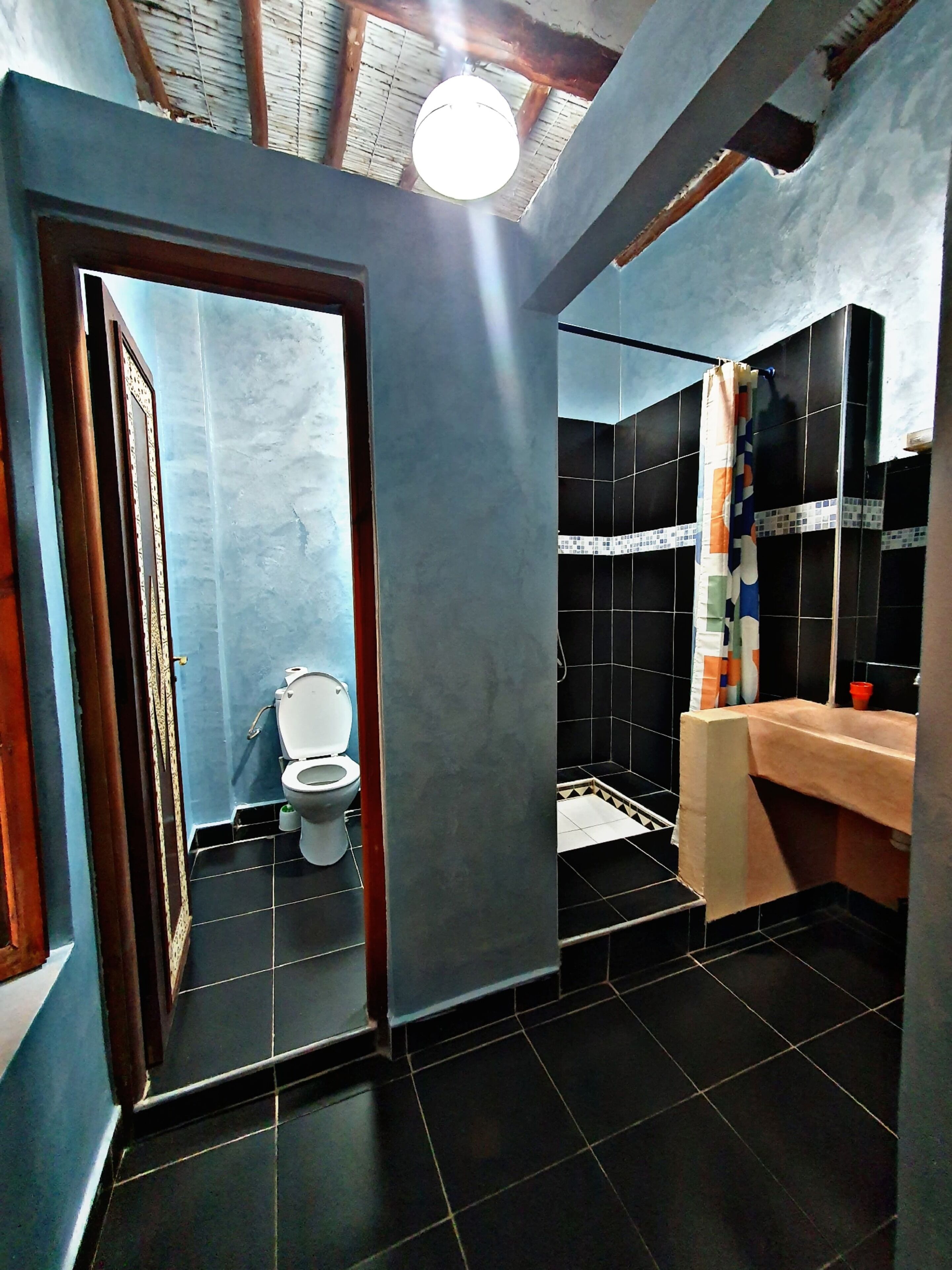 A bathroom with a toilet, sink, and shower area.