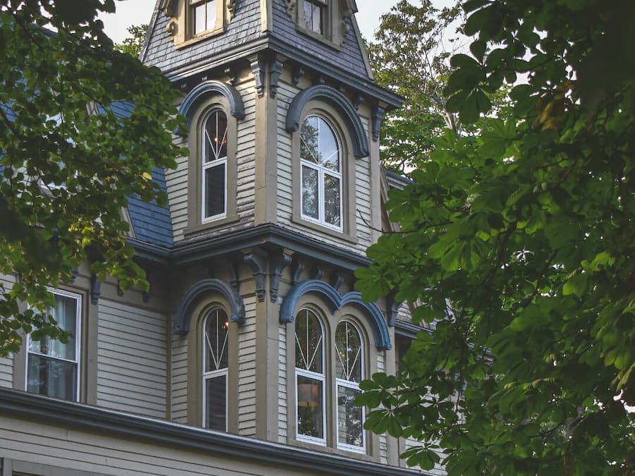 A Victorian-style building with a prominent tower, large windows, and a balcony.