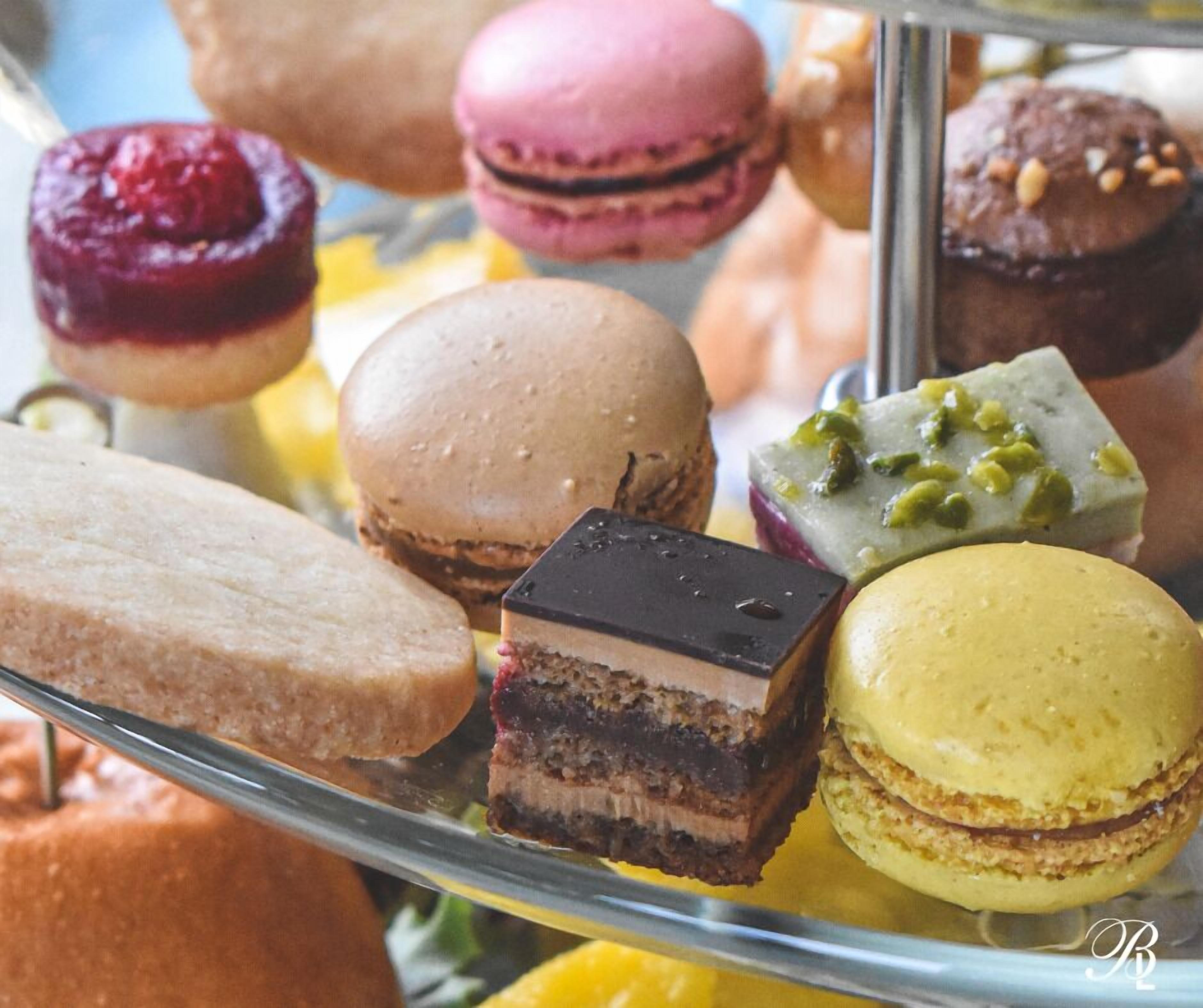 A variety of pastries displayed on a glass stand.