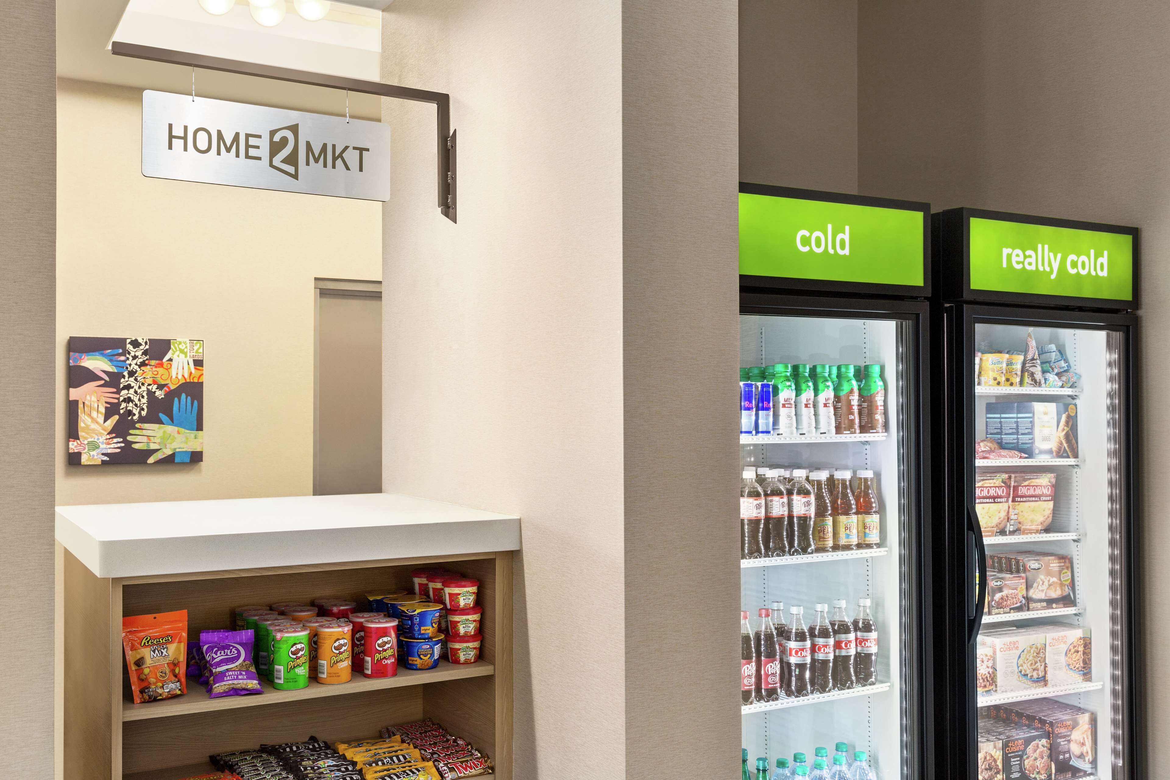 A vending area with snacks and beverages, a sign reading "HOME MKT", and two refrigerators labeled "cold" and "really cold".