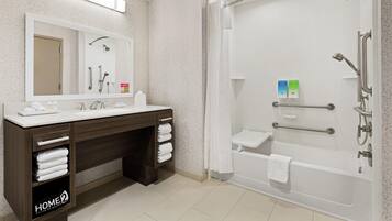 Un baño moderno con ducha, bañera, tocador con espejo y toallero.