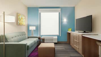 A modern hotel room with a sofa, a flat-screen TV, a desk, a lamp, and a window.