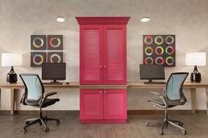Un espace de bureau moderne comprenant deux bureaux, chacun équipé d’un ordinateur, d’une lampe et d’un fauteuil ergonomique.