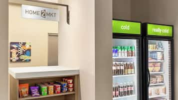 A hotel reception area with a sign that reads 'HOME MKT' and two refrigerators labeled 'cold' and 'really cold'.