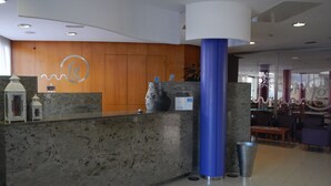 A reception area with a marble counter, a blue pillar, and a wooden wall with a logo. - Hotel Fenals Garden (Lloret de Mar)