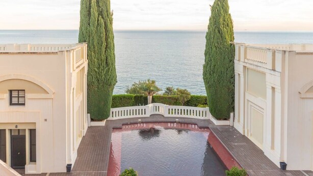 A rooftop pool with a view of the sea, surrounded by white buildings and tall cypress trees. - Apartamento Anfiteatro by Costa CarpeDiem (Calpe)