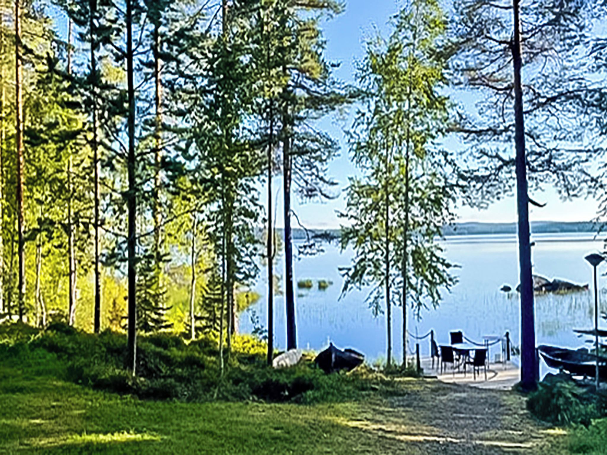 Un campamento junto al lago con tiendas de campaña, una mesa y sillas.