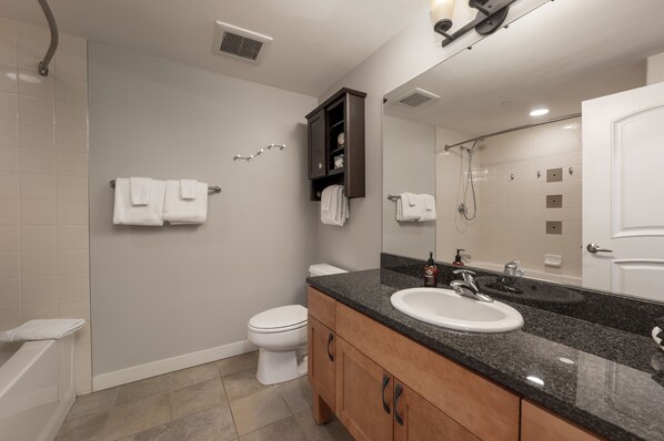 A modern bathroom with a sink, mirror, and toilet.