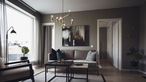 A modern living room with a sofa, coffee table, and a large window.