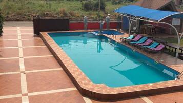 Una piscina al aire libre, tumbonas
