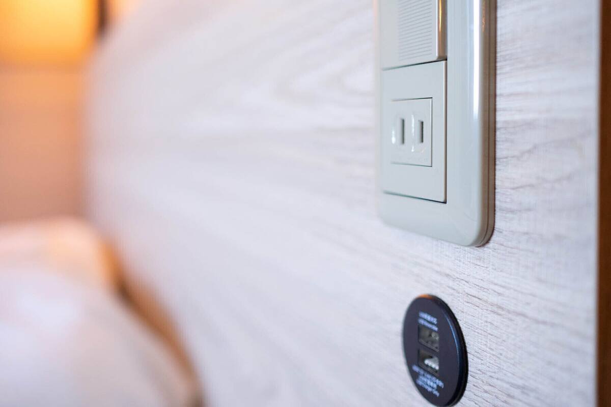 Gros plan d’une prise électrique murale et d’un panneau de commande doté d’une interface circulaire.