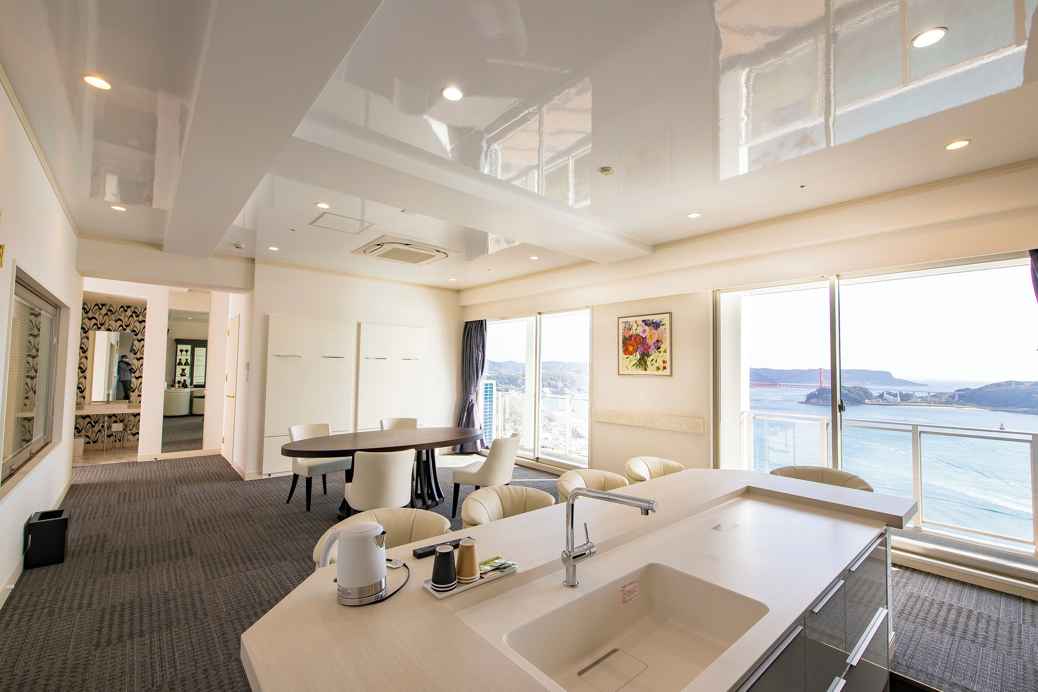 Una habitación de hotel moderna con un ventanal grande, un área de comedor y una cocina.
