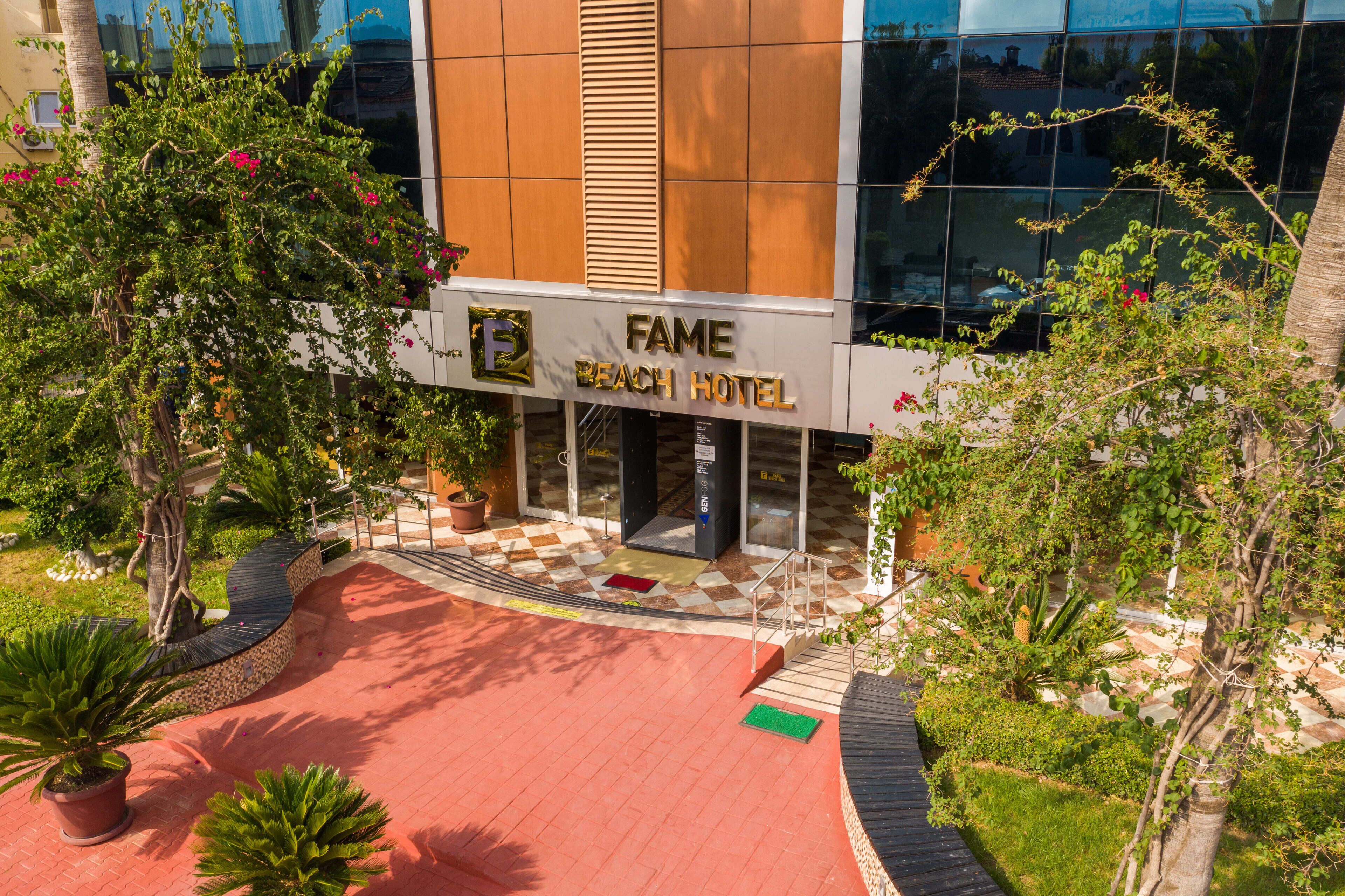 Un hotel moderno con una entrada destacada, un jardín bien cuidado y una vista clara de la fachada.