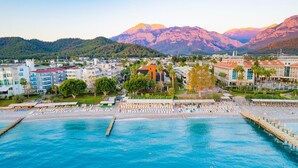 Une station balnéaire dotée d’une piscine, d’une plage et offrant une vue sur les montagnes.