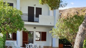 A two-story building with a balcony, outdoor seating area, and surrounding greenery. - Beach house with large garden (Seaside Paradise Vasto) (Vasto)