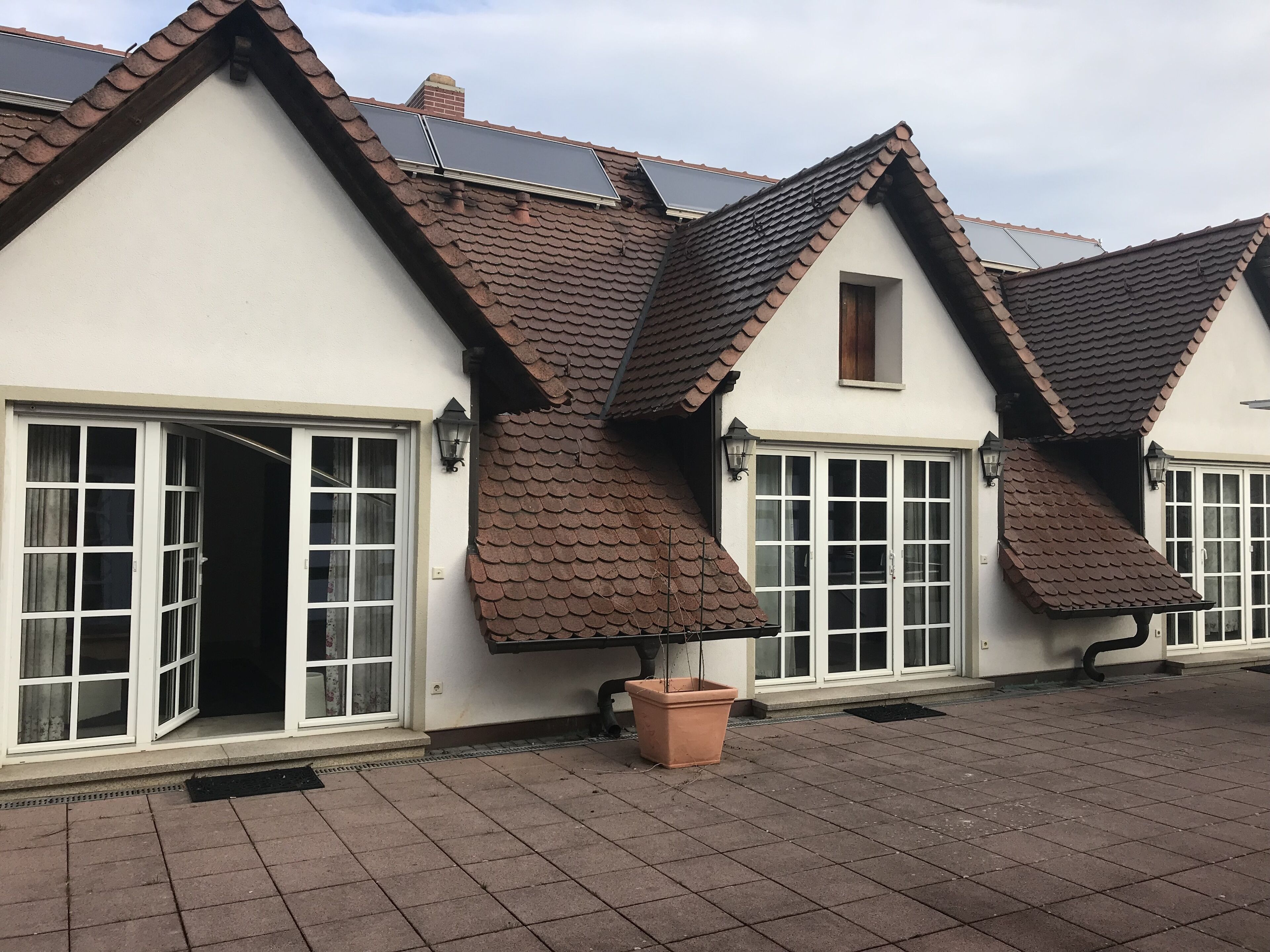 A row of houses with pitched roofs and large windows.